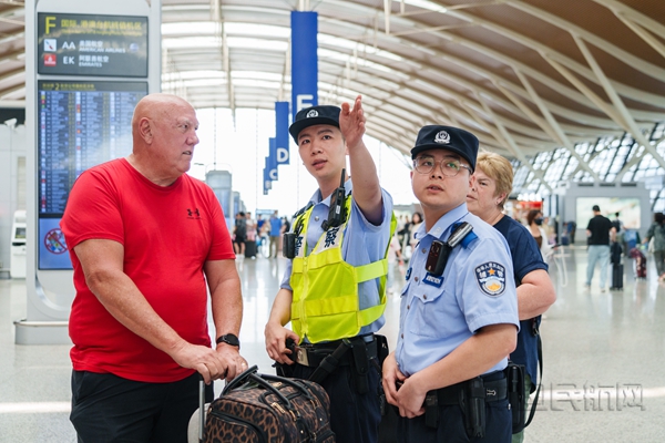 浦东机场候机楼治安派出所民警为外籍旅客开展指引-上海机场供图