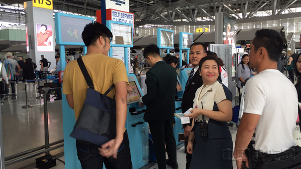 附图2：曼谷素万那普国际机场工作人员协助旅客办理自助值机.jpg