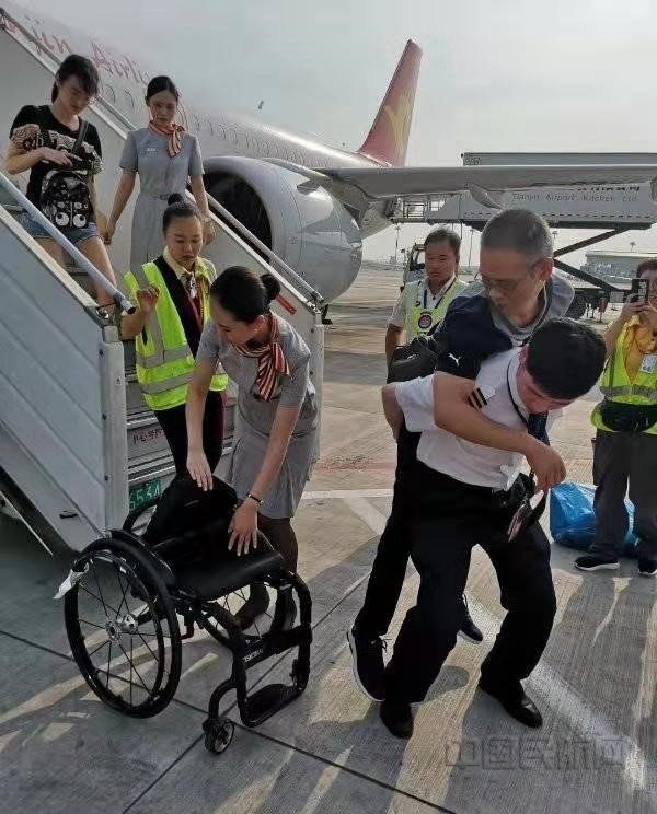 图七 机长背行动不便旅客乘坐轮椅06.jpg 图七 机长背行动不便旅客乘坐轮椅06.jpg