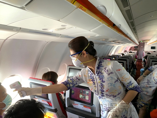 nEO_IMG_图 海南航空乘务员在航班上为旅客测温.jpg